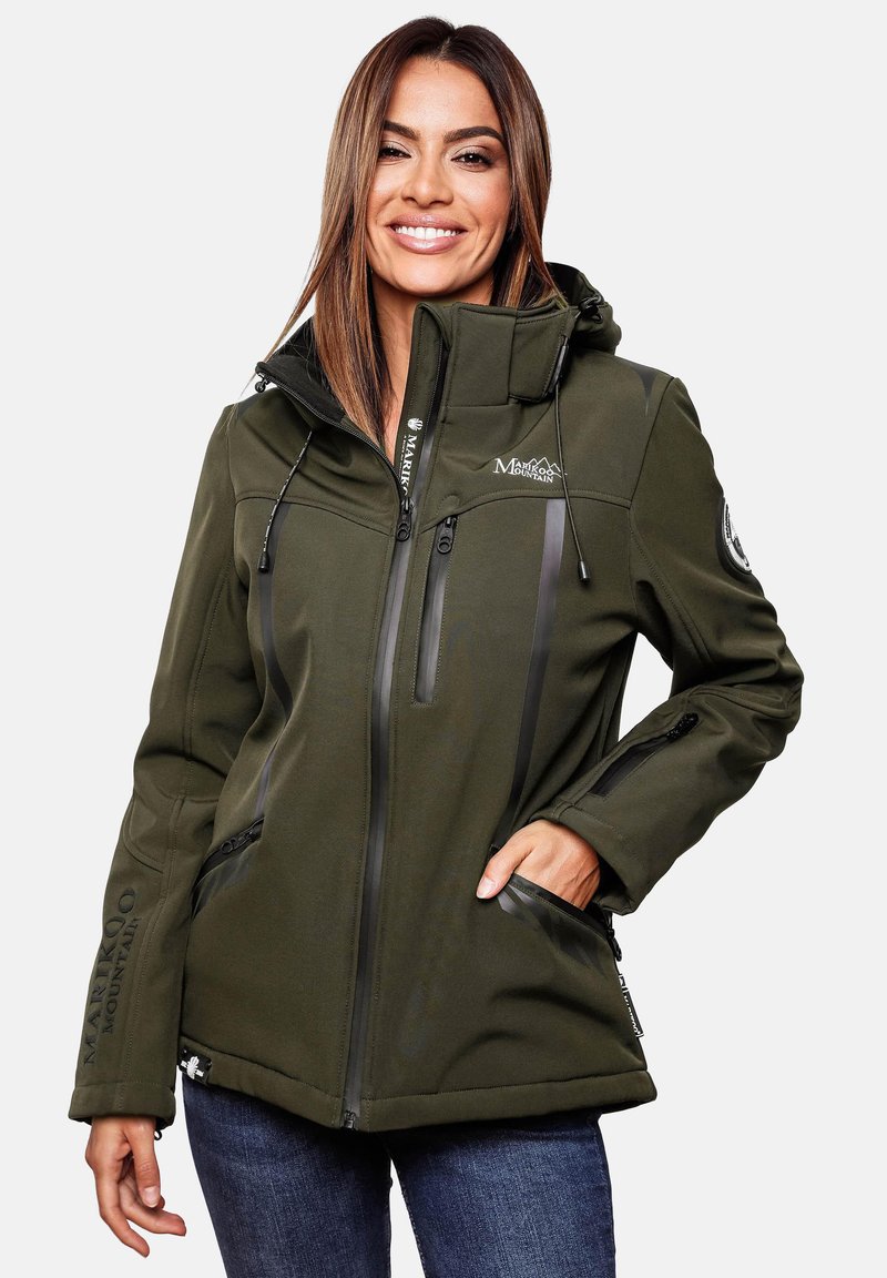 Woman smiling wearing an olive green Marikoo Mountain zip-up jacket with hood, black zipper details, and blue jeans, hand in pocket.