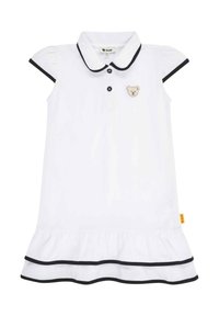 Witte polojurk met korte pofmouwen, zwarte afwerking, een knoopsluiting en een geborduurd berenpatch op de borst. Rimpelzoom.