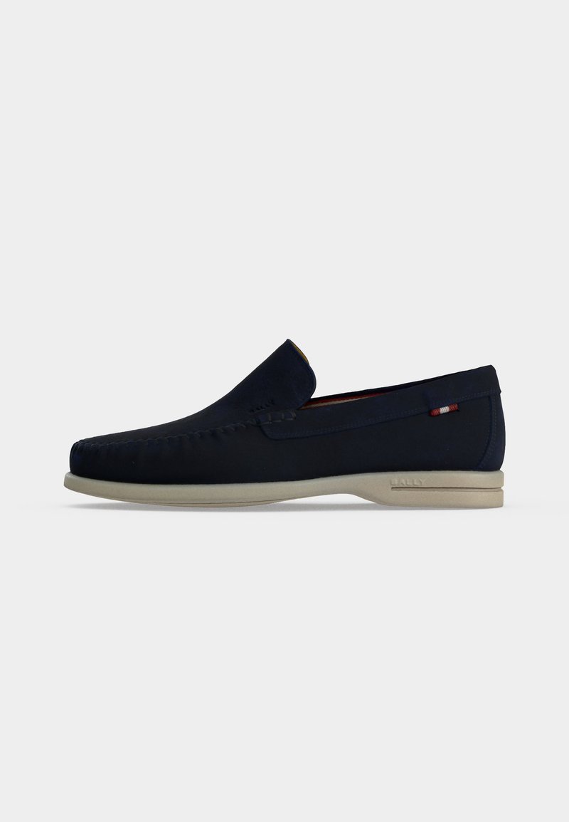Σκούρο μπλε ναυτικό loafer slip-on με μπεζ σόλα, ραφή moc toe και μικρή υφασμάτινη λεπτομέρεια στο πλάι.