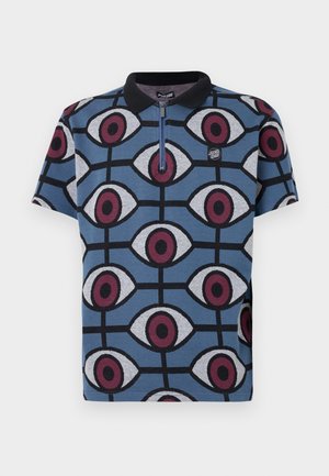 Polo à manches courtes avec une base bleu foncé ornée d'un motif d'yeux stylisés en bordeaux et gris. Comprend un col noir et une fermeture éclair.