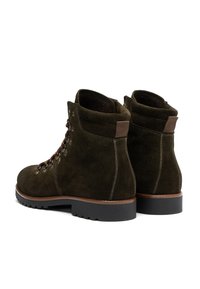 Pair of dark green suede hiking boots with brown laces, padded collars, and black rubber soles on white background.