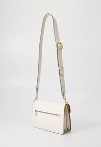 White leather handbag with a structured design, gold-tone hardware, a front zipper pocket, and an adjustable strap.