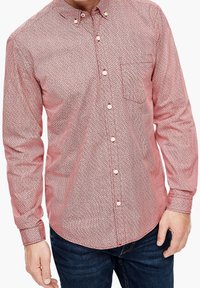 Camisa de botón de manga larga en rojo con un patrón texturizado en blanco. Presenta un bolsillo y botones blancos a lo largo del frente.
