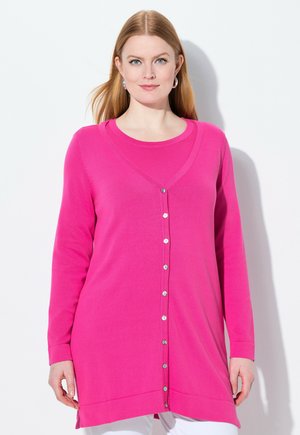 Langärmelige Strickjacke in leuchtendem Pink, mit V-Ausschnitt, Knopfverschluss, glatter Textur und seitlichen Schlitzen am Saum. Innenlage in Weiß sichtbar.