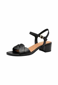Sort lædersandal med et snoet frontdesign, åben tå og ankelrem. Har en lav blokhæl og en korklignende indersåle.