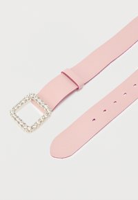 Ροζ δερμάτινο λουρί με τετράγωνη αγκράφα διακοσμημένη με στρας. Διαθέτει ανάγλυφη επιφάνεια και πολλά τρύπες για ρύθμιση μεγέθους.