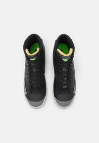 Höga sneakers med övre i svart läder, gröna detaljer, vadderad krage och grå tåkappa; har svarta snören och texturerad innersula.