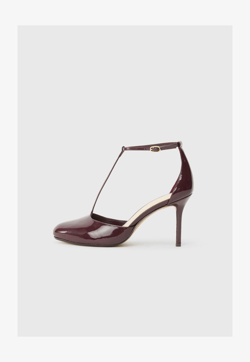 Chaussure à talon haute en cuir verni bordeaux avec un bout pointu, design de lanière en T et accents en métal doré.