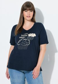 Marineblå bomulds-t-shirt med v-udskæring, korte ærmer, med sky-grafik og teksten "collect beautiful moments" i creme og grå.