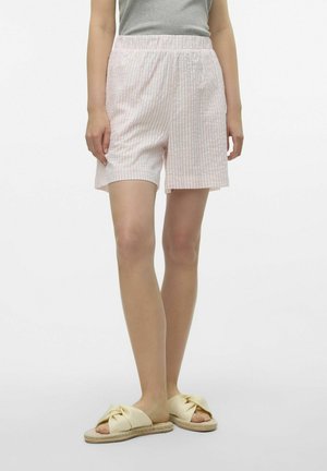 Lichtroze en witte gestreepte shorts met een elastische tailleband, zittend boven de knie, gecombineerd met gele geknoopte slippers.