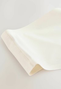 Kremasti materijal drapiran pod kutem, glatke texture i s finim rubovima te suptilnim detaljem šivanja. Lagani, fleksibilni materijal.