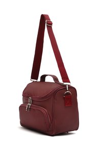 Bolso sintético rojo con asa superior y correa ajustable, que cuenta con dos compartimentos con cremalleras y un pequeño acento de etiqueta. Textura suave.