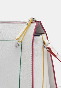 Bolso de mano de cuero blanco texturizado con costuras de colores en verde, amarillo, rojo y rosa. Cuenta con una cremallera y una correa desmontable.