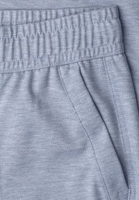 Světle modrá látka s jemným károvaným vzorem, s elastickým pasem a boční kapsou s viditelným šitím.