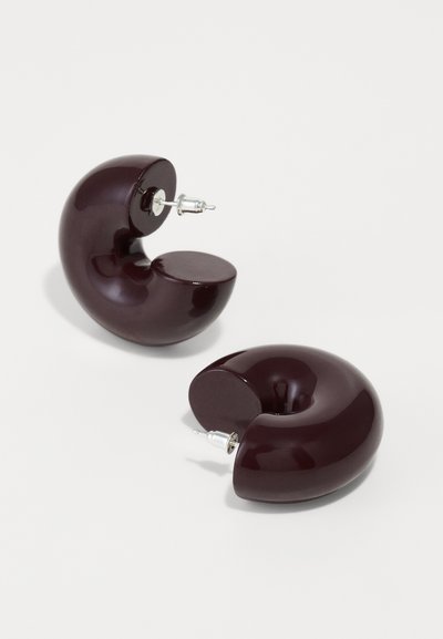 Boucles d'oreilles en résine bordeaux en forme de coquillage courbé, avec une surface brillante et un matériel en argent pour un attachement sûr.