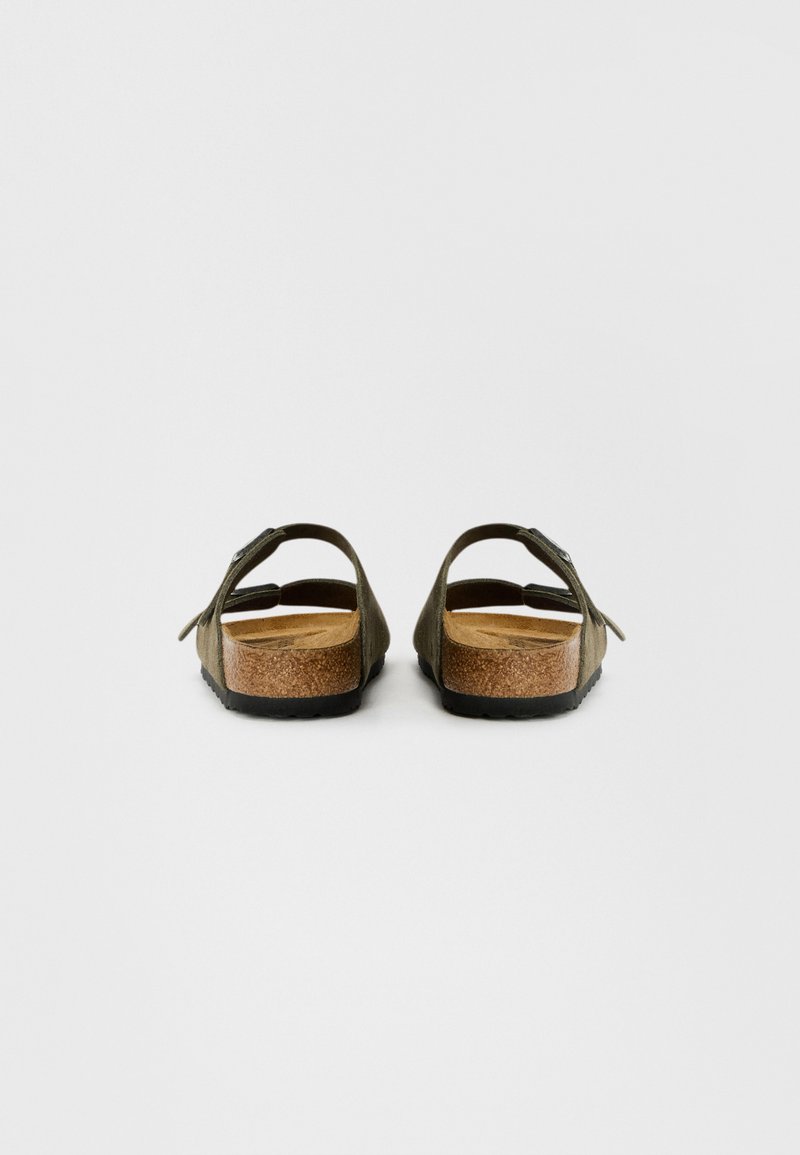 Sandales avec semelle en liège vert olive, dotées de brides réglables et d'un support au niveau du talon arrière. Tige en daim doux, semelle extérieure texturée pour une meilleure adhérence.