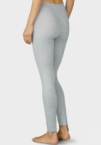 Lichtgrijze leggings van een zachte, rekbare stof, met een hoge taille en een aansluitende pasvorm tot aan de enkels.