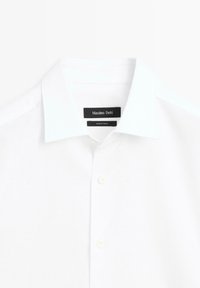Witte overhemdd met een textuurstof, vijf knoopsluiting en kledinglabel "Massimo Dutti" met een "Made in Turkey" label.