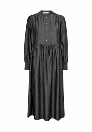 Rochie neagră cu mâneci lungi și guler înalt, cu închidere prinsă cu nasturi, talie strânsă și mici puncte albe. Tesătură netedă cu o siluetă fluidă.
