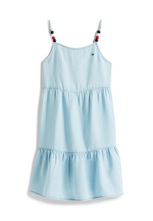 Lyseblå ermeløs kjole med lagdelt skjørt, justerbare skulderstropper pyntet med røde og svarte perler, og liten rød, hvit og blå logo på brystet.