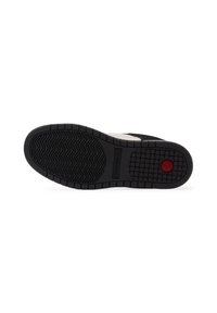 Fekete sneaker talp, textúrált tapadási mintázattal, melyen piros kör alakú díszítés található. Az anyag gumi jellegű, szilárd, sportos kialakítással.