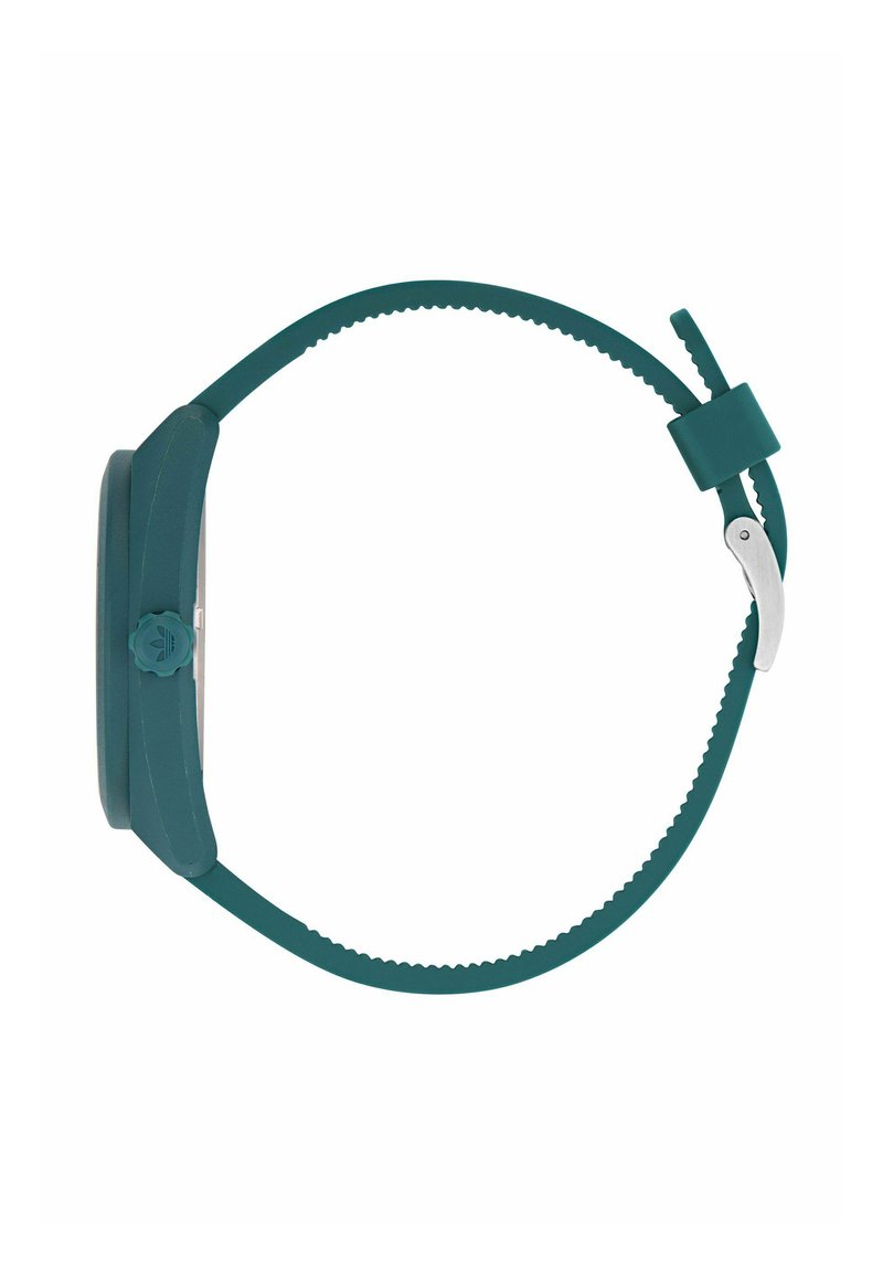 Reloj de pulsera de silicona verde azulado con esfera redonda, correa texturizada y hebilla de metal. Presenta un diseño simple con una corona lateral prominente para ajustes.