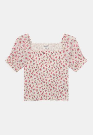 Top corto blanco fruncido con estampado floral en rosa y púrpura, mangas cortas abullonadas y escote cuadrado.