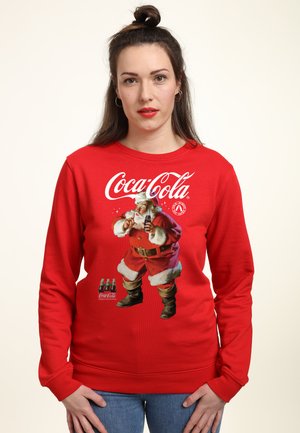 Rotes Sweatshirt mit einem Coca-Cola-Logo und einer Weihnachtsmann-Grafik. Mit langen Ärmeln, einem runden Ausschnitt und einer gemütlichen Textur.