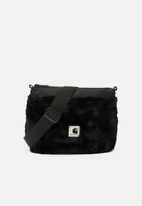Čierna kabelka na crossbody z umelej kožušiny s lesklým vrchom, nastaviteľným popruhom a štvorcovou nášivkou s logom. Mäkká textúra a uzavieranie na zips.