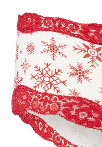 Vitt tyg med röd snöflingeprint, med en röd spetskant längs den övre kanten. Spetsen har ett intrikat mönster med blomsterdekorationer.