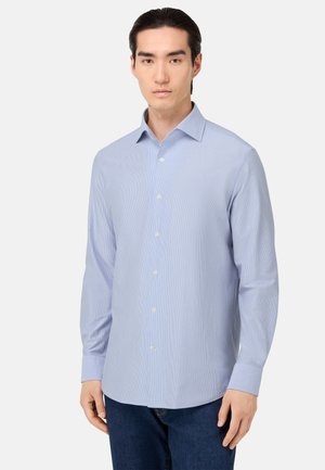 Camisa de manga larga azul claro con cuello abotonado, que presenta un sutil patrón a rayas y una textura suave. Corte clásico con cierre de botones al frente.