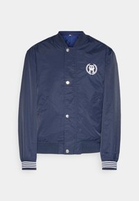 Navy blue bomber jacket with a snap button closure, two side pockets, striped ribbed cuffs, and a white logo with a laurel design on the chest.