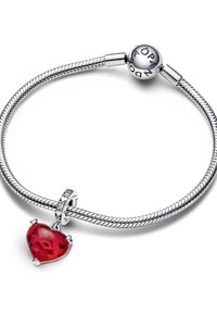 Bracciale in catena d'argento con charm a forma di cuore rosso, caratterizzato da faccettature e una chiusura decorativa con accenti trasparenti. Superfici lisce e riflettenti.