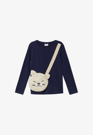 Chemise à manches longues navy associée à un sac rond crème ressemblant à un chat, fabriqué dans un matériau texturé imitant la fourrure et doté d'une bandoulière.