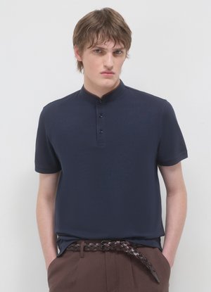 Polo blu navy con maniche corte e colletto alla coreana. Presenta tre bottoni nascosti e una texture liscia e leggera.
