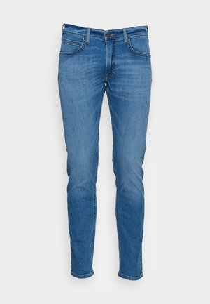 Jeans in denim blu con una vestibilità slim, caratterizzati da cinque tasche, passanti per cintura e dettagli in cucitura arancione. Texture liscia con un finish sbiadito.