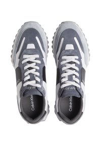 Zapatillas Calvin Klein con parte superior de ante y malla en color gris, acentos blancos, cordones redondos y una suela de goma texturizada con un patrón de tracción robusto.