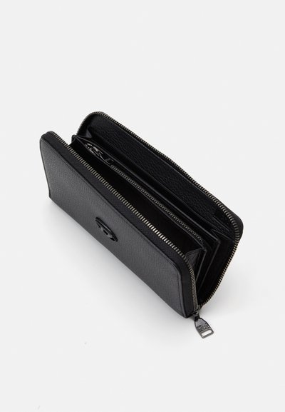 Portefeuille en cuir noir avec une finition texturée, fermeture éclair tout autour et plusieurs compartiments pour cartes et billets. Détail de tirette en métal visible.