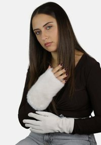 Biały mankiet podszyty futrem oraz biała skórzana rękawiczka o gładkiej fakturze, zaprojektowane dla zapewnienia ciepła. Model prezentuje oba akcesoria.