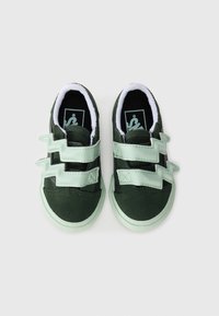 Baskets pour tout-petits en vert foncé avec des sangles Velcro zigzag vert menthe et des semelles vert clair sur fond blanc.