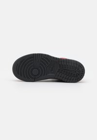 Nike sportssko sula, svart gummi med texturerat mönster. Har cirkulära och horisontella linjer, med logotyp nära mitten.