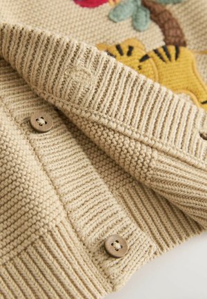 Beige knitted cardigan with ribbed hem, featuring wooden buttons and a textured pattern. Embroidered floral design accentuates the fabric.