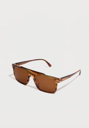 Ορθογώνια γυαλιά ηλίου με σχέδιο χελώνας, φακούς καφέ απόχρωσης και λεπτούς βραχίονες, τοποθετημένα σε λευκό φόντο.