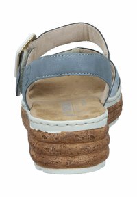 Sandales en cuir gris avec un talon en liège, une semelle blanche et une sangle ajustable. Texture lisse avec une couture minimale visible sur les bords.