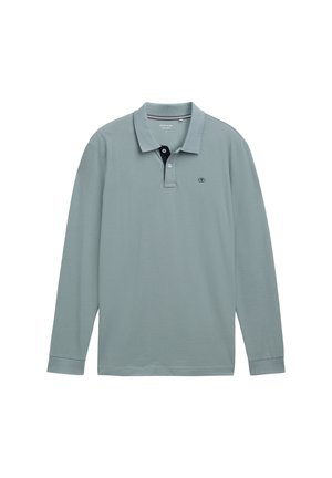 Polo à manches longues bleu clair avec un col contrastant marine. Matière en coton, avec un petit logo sur la poitrine gauche. Coupe classique.