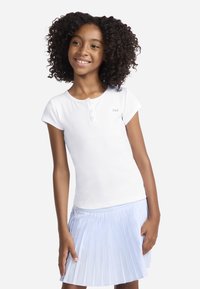 Λευκό κοντομάνικο ριμπ μπλουζάκι με κουμπωτό πλακέ και μικρό λογότυπο. Συνδυασμένο με φούστα με πιέτες σε ανοιχτό μπλε χρώμα.