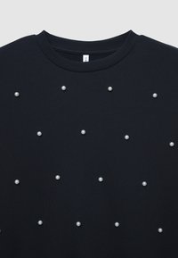 Felpa nera con girocollo, decorata con piccole perle bianche disposte in un motivo sparso sul davanti. Tessuto morbido.