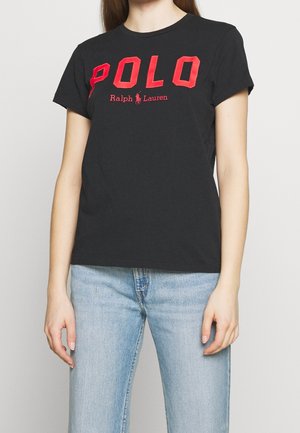 Czarny bawełniany t-shirt z wyraźnym czerwonym napisem "POLO" oraz logo "Ralph Lauren", okrągłym dekoltem i krótkimi rękawami, w połączeniu z jasnoniebieskimi dżinsami.