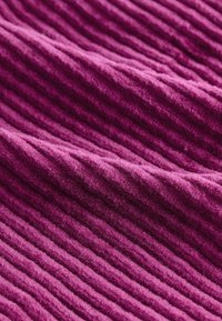 Tessuto in velluto a coste viola, con righe verticali, caratterizzato da una consistenza morbida e linee equidistanti, creando una superficie tattile.