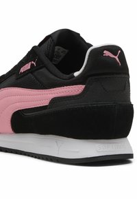 Zwarte sneaker met een roze PUMA-logo en streep. Van suede en mesh materialen. Dikke witte zool met "SOFTRIDE" detail. Gestructueerde accenten.